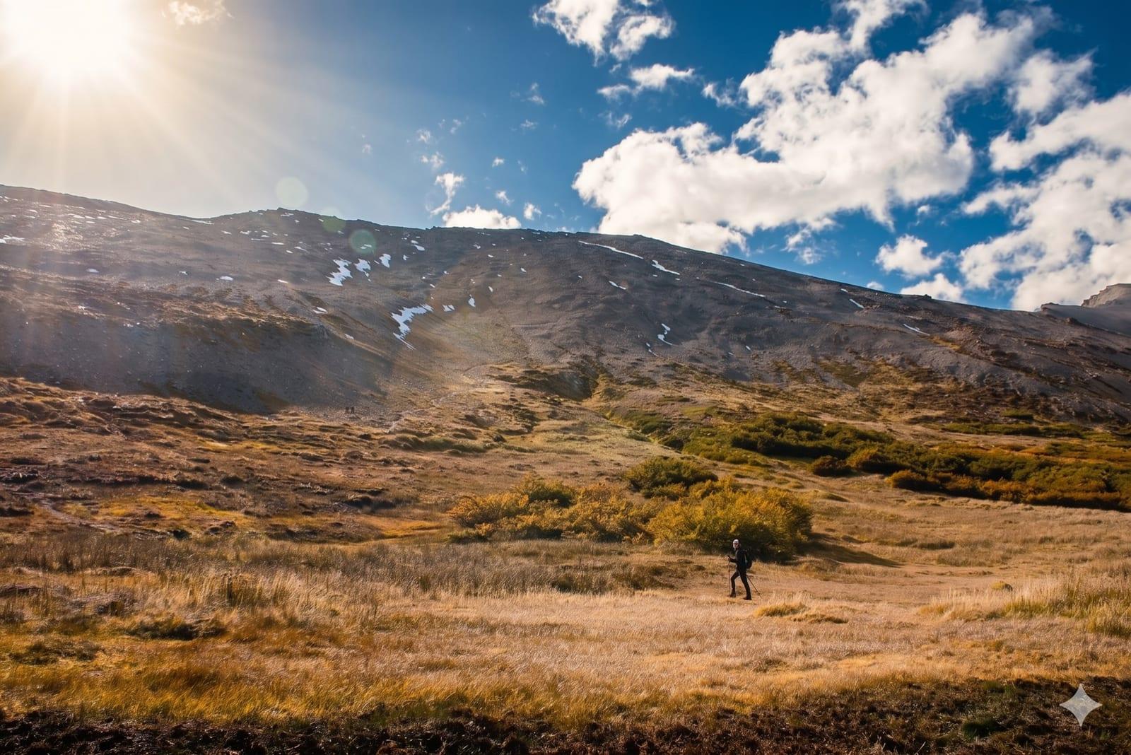 Senderista cruzando la pampa dorada con el Cerro Guanaco al fondo
