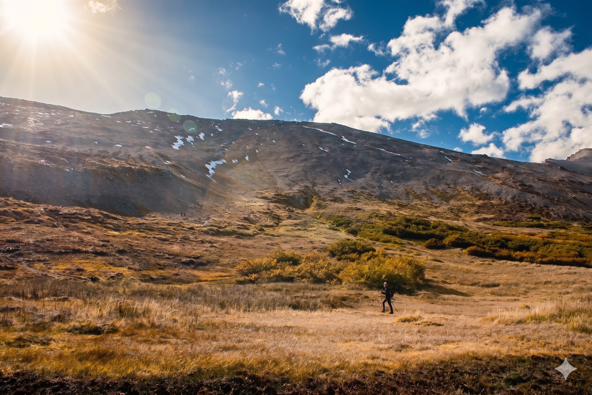Senderista cruzando la pampa dorada con el Cerro Guanaco al fondo